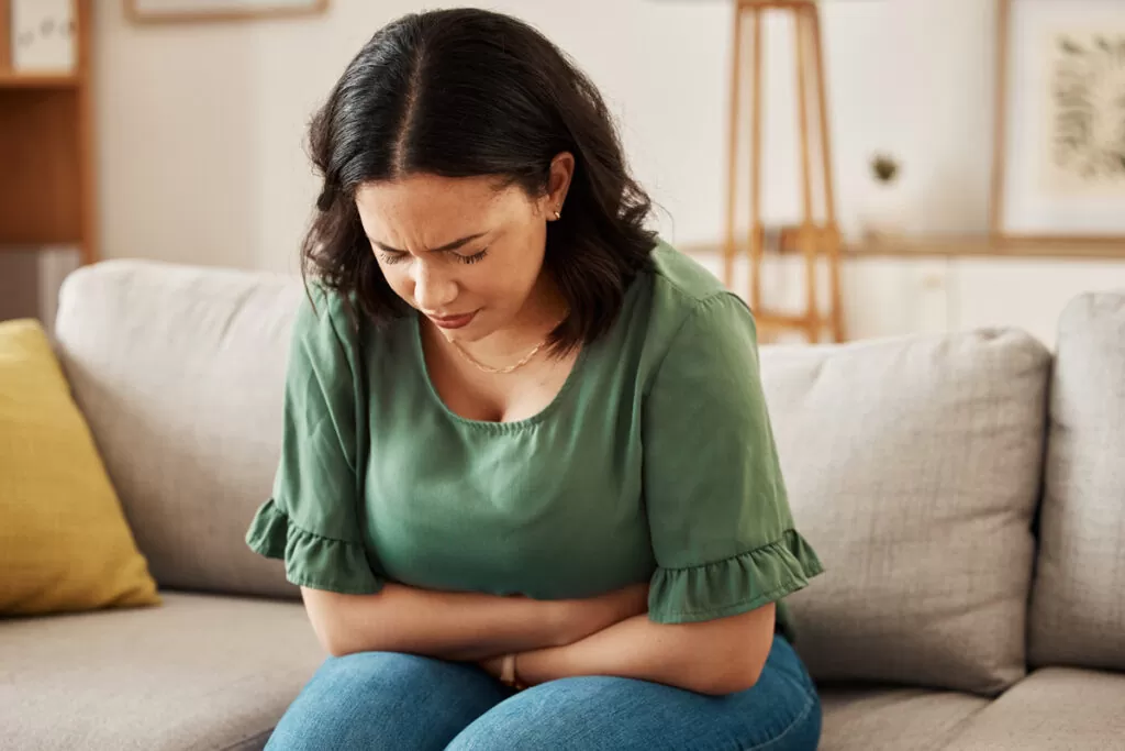 A person in a green shirt on a couch suffering from anxiety in Chicago.