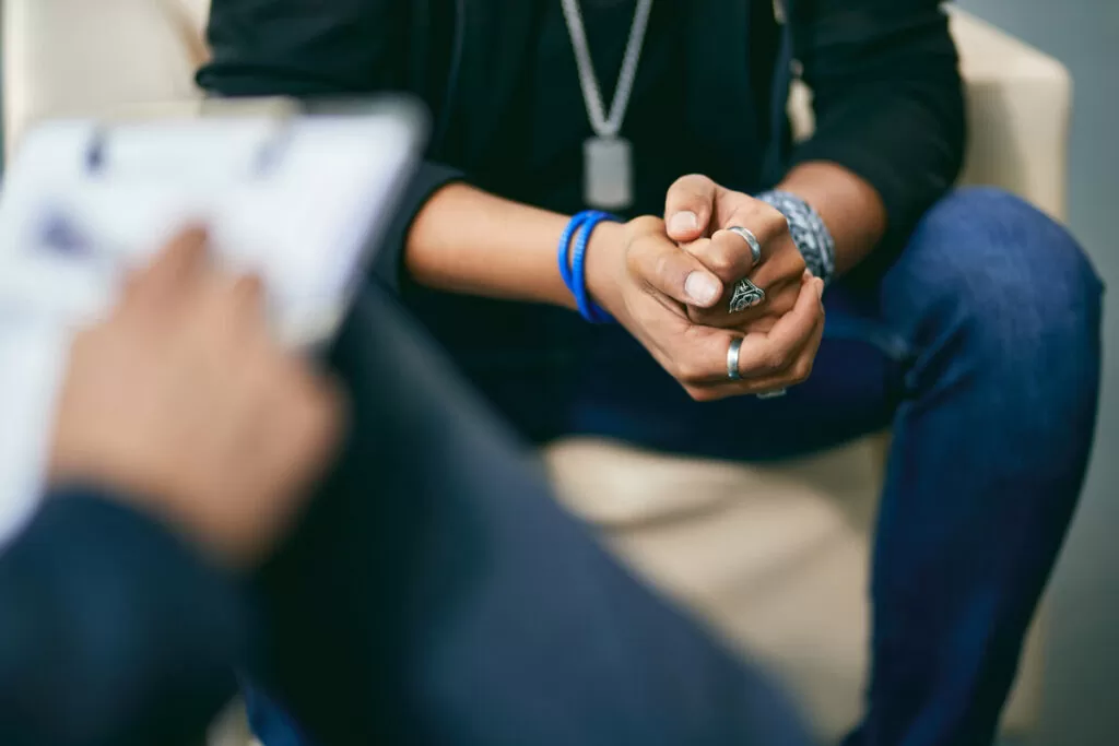 A man holding his hands together during trauma therapy in Chicago.